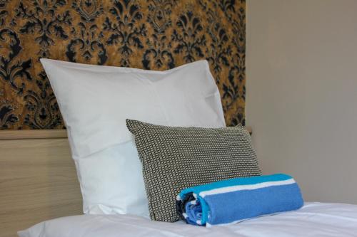 塔林Villa Kadriorg Hostel的床上的蓝色和白色枕头,配有枕头