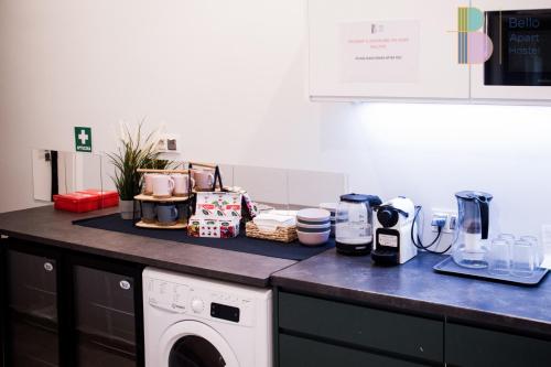 华沙Kapsuły Bello ApartHostel的厨房柜台配有洗衣机和洗衣机。
