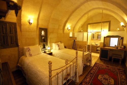于尔居普Hancı Cave Hotel的一间卧室,配有两张床