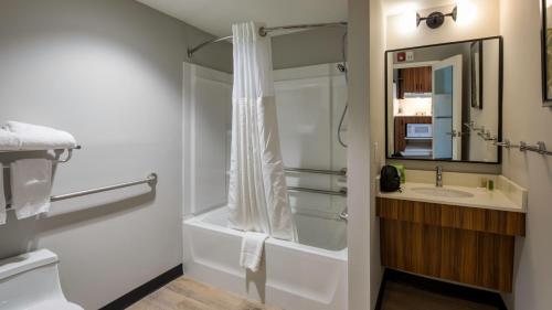 康科德Uptown Suites Extended Stay Charlotte NC - Concord的带淋浴和盥洗盆的浴室