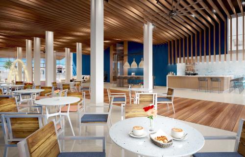 辛普森湾The Morgan Resort Spa & Village的餐厅设有白色的桌椅和蓝色的墙壁