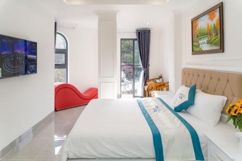 头顿Sun Hill Hotel的一间卧室配有一张大床和一张红色椅子