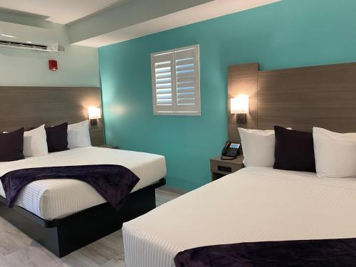 洛根Worthington of Logan的酒店客房设有两张床和蓝色的墙壁。
