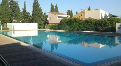 阿格德角网球国际酒店的一座房子前面的蓝色海水游泳池