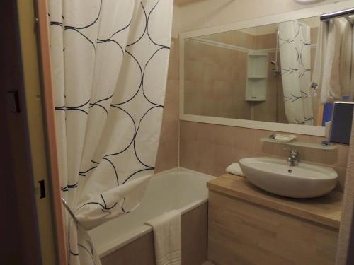 阿格德角网球国际酒店的一间带水槽、浴缸和镜子的浴室