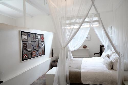路易特里哈特马迪塔瓦山林小屋的卧室配有带白色窗帘的天蓬床
