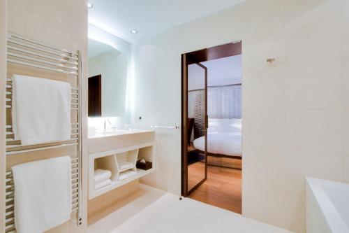 瓦朗斯皮克住宅酒店的带淋浴、盥洗盆和浴缸的浴室