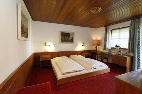 慕尼黑纽马尔酒店的一间卧室配有一张床、一张书桌和一个窗户。