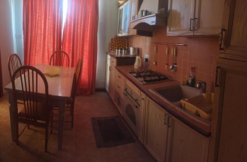 QrendiIL bejta的厨房配有桌子、水槽和炉灶。