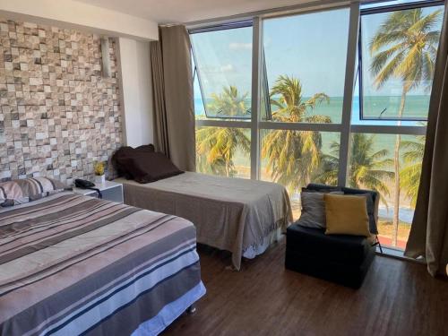 若昂佩索阿Flat vista Mar的酒店客房设有一张床和一个大窗户