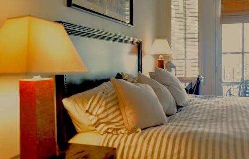 拉昆塔Beautiful Casita, La Quinta Legacy Villas Resort的一间卧室配有带白色枕头和灯的床