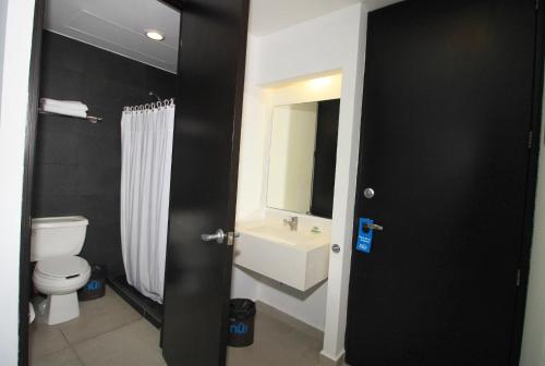 韦拉克鲁斯努酒店的浴室配有白色卫生间和盥洗盆。