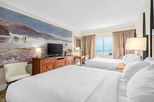 长滩The Inn at Long Beach的酒店客房设有两张床和一台平面电视。