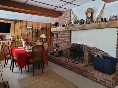 蓝山鲍尔宁旅馆 的客厅设有砖砌壁炉、桌子和椅子