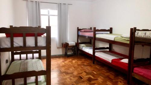 尤西德福拉Hostel Tropeiro de Minas的客房设有三张双层床和一扇窗户。