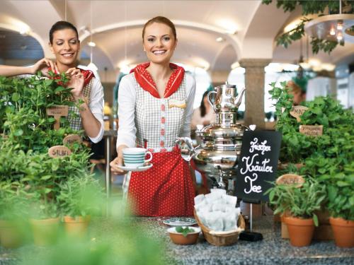 奥滕巴赫兰泽特高速公路-施泰因豪斯餐厅维也纳酒店的两个女人在花店里拿着一杯咖啡