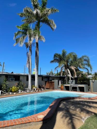 鲍恩皇后海滩酒店的一座棕榈树环绕的游泳池
