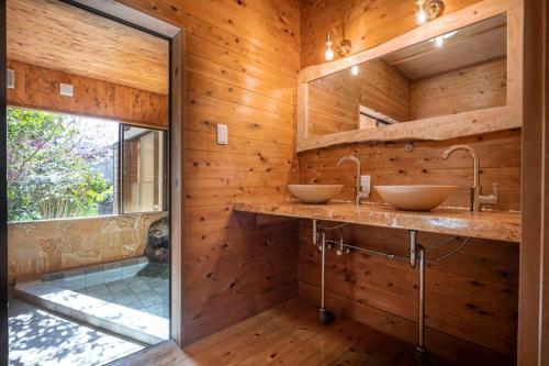 河津町懐-KAI-的浴室设有木墙和2个水槽。