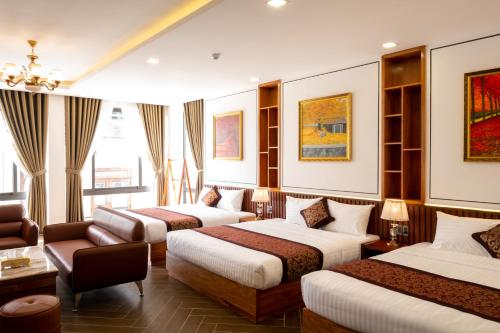 大叻La Fleur Premium Central Apartment Hotel的酒店客房,设有三张床和一张沙发