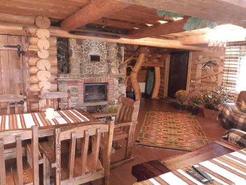 沃罗赫塔Guest House Dikiy Zrub的客厅设有石制壁炉和木制家具。