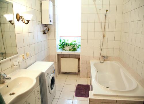 基辅Kashtan guest house的白色的浴室设有浴缸和水槽。