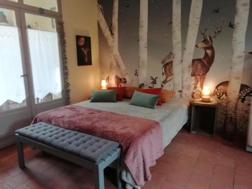 Thoiré-sur-DinanLa Haute Forge Maison d'Hôtes的卧室配有一张床,墙上挂着鹿