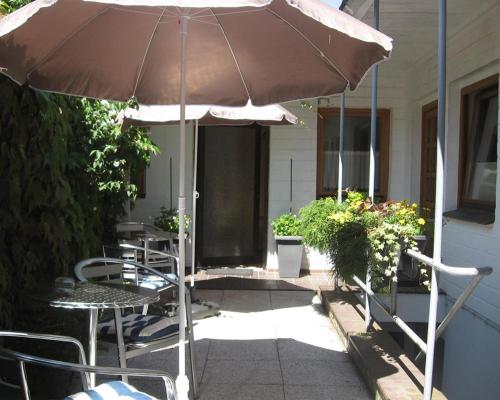 巴特施瓦尔陶Altes Schulhaus的庭院配有遮阳伞和桌椅。
