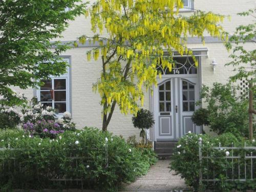 巴特施瓦尔陶Altes Schulhaus的白色的房子,有灰色的门和鲜花