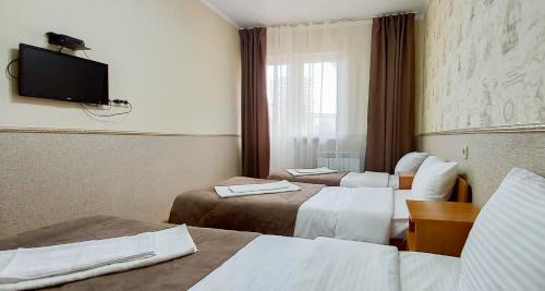阿德勒Albatros Guest House的酒店客房设有两张床和一台平面电视。