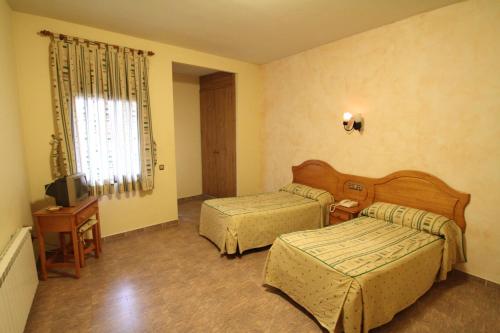 Calera y Chozas库阿特罗卡米诺斯餐厅旅馆的酒店客房设有两张床和电视。