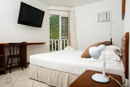 弗洛里亚诺波利斯Ilha Náutica的卧室配有白色的床和电视。