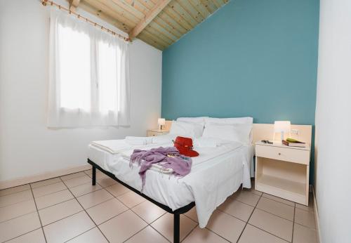 波坦察皮切纳港Natural Village Resort的卧室配有白色的床和蓝色的墙壁