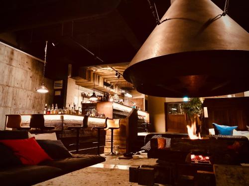 箱根RoheN Resort&Lounge HAKONE的客房设有带沙发的酒吧和大型灯具