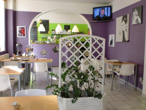 列日莱斯艾克特斯酒店的餐厅拥有紫色的墙壁和桌子,种植了植物