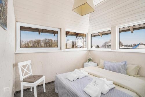 GirininkaiVila 9Vėjai的配有窗户和椅子的客房内的两张床