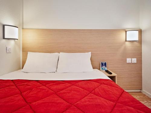 塞尔吉瑟伊圣克利斯朵夫普瑞米尔经典酒店的一间卧室配有一张带红色毯子的大床