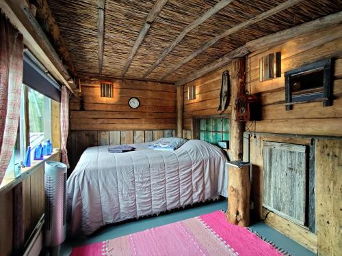 VolttiLapuanjoen Rantakeidas的木制客房内的一间卧室,配有一张床