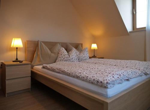 费尔特拉科什Huber Vendégház的一间卧室配有一张带枕头的床和两盏灯。