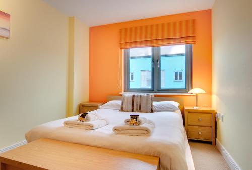 盖茨黑德Stephenson Sleepers Apartments by Week2Week的卧室配有带2条毛巾的窗户,位于床上