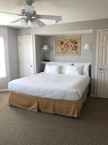 加尔维斯敦Holiday Inn Club Vacation Galveston Seaside Resort的卧室配有一张白色大床和吊扇