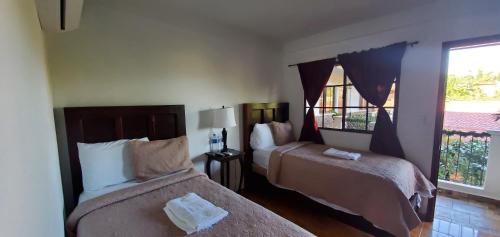 康塞普西翁德阿塔科Hotel & Restaurant Fleur de Lis的酒店客房设有两张床和窗户。