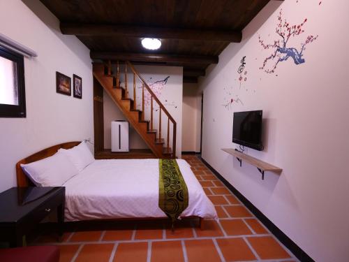 金宁乡金門后倉七號新古厝民宿的一间卧室设有一张带楼梯的床和一台电视。