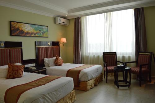 姆特瓦拉Tiffany Diamond Hotels - Mtwara的酒店客房,配有两张床和椅子