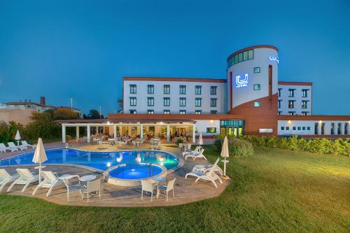 卡尔博尼亚卡尔博尼亚卢酒店的一座带游泳池和椅子的酒店和一座建筑