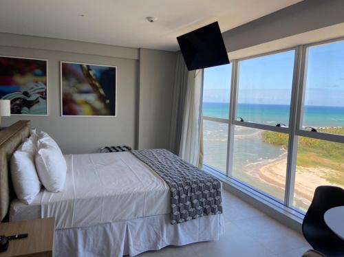 累西腓Paiva Flat Home Stay - Barra de Jangada的一间卧室配有一张床,享有海景