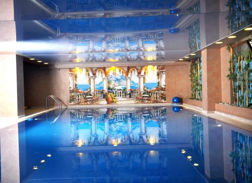 甘贾Deluxe Hotel Ganja的大楼内带桌椅的游泳池