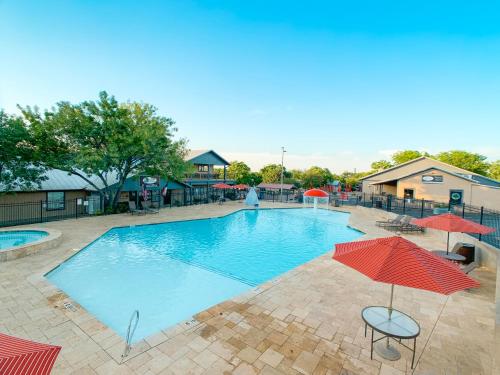 新布朗费尔斯Sun Retreats Texas Hill Country的一个带遮阳伞的大型游泳池,背景人员