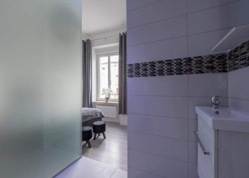 卢森堡EXECUTIVE DOUBLE ROOM WITH EN-SUITE in GUEST HOUSE RUE TREVIRES R3的白色的浴室设有水槽和窗户。