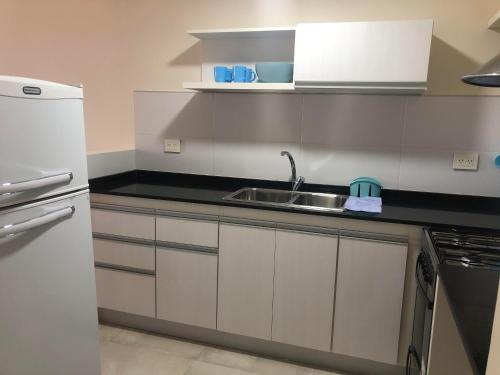 玛德琳港Arenas- Departamento de playa的厨房配有水槽和冰箱