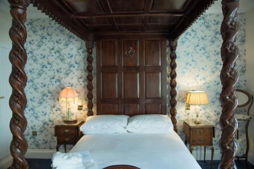 巴茅思The Royal的一间卧室配有一张带蓝花壁纸的天蓬床。